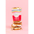 Stack of marshmallow cookies with a colorful packaging on a pink background